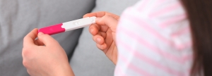 Junge Frau mit einem Schwangerschaftstest in der Hand