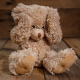 Ein trauriger Teddy, der auf einem Holzboden sitzt.